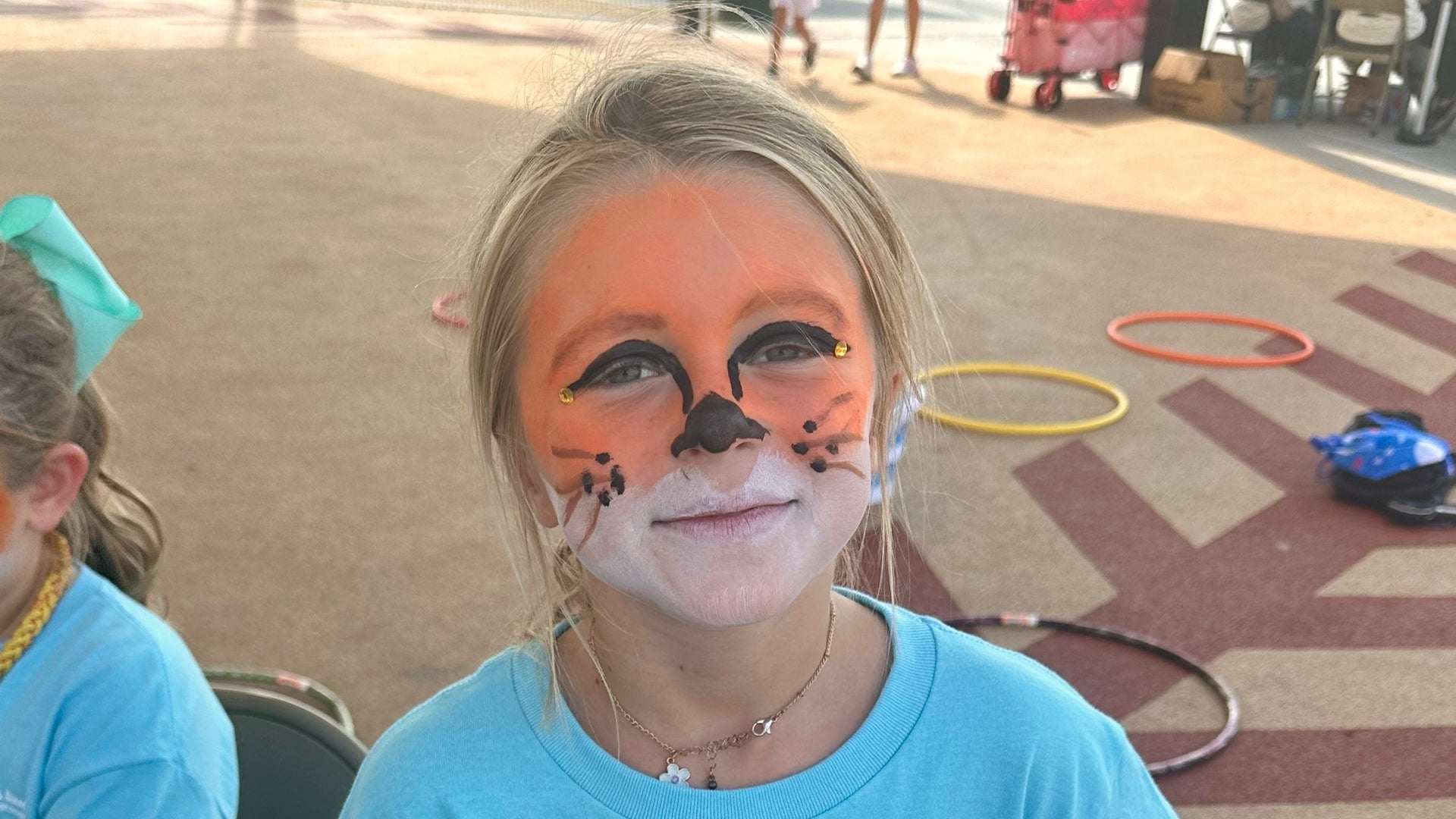 Girl with tiger face paint at the 2025 Derricks and Diamonds softball charity tournament