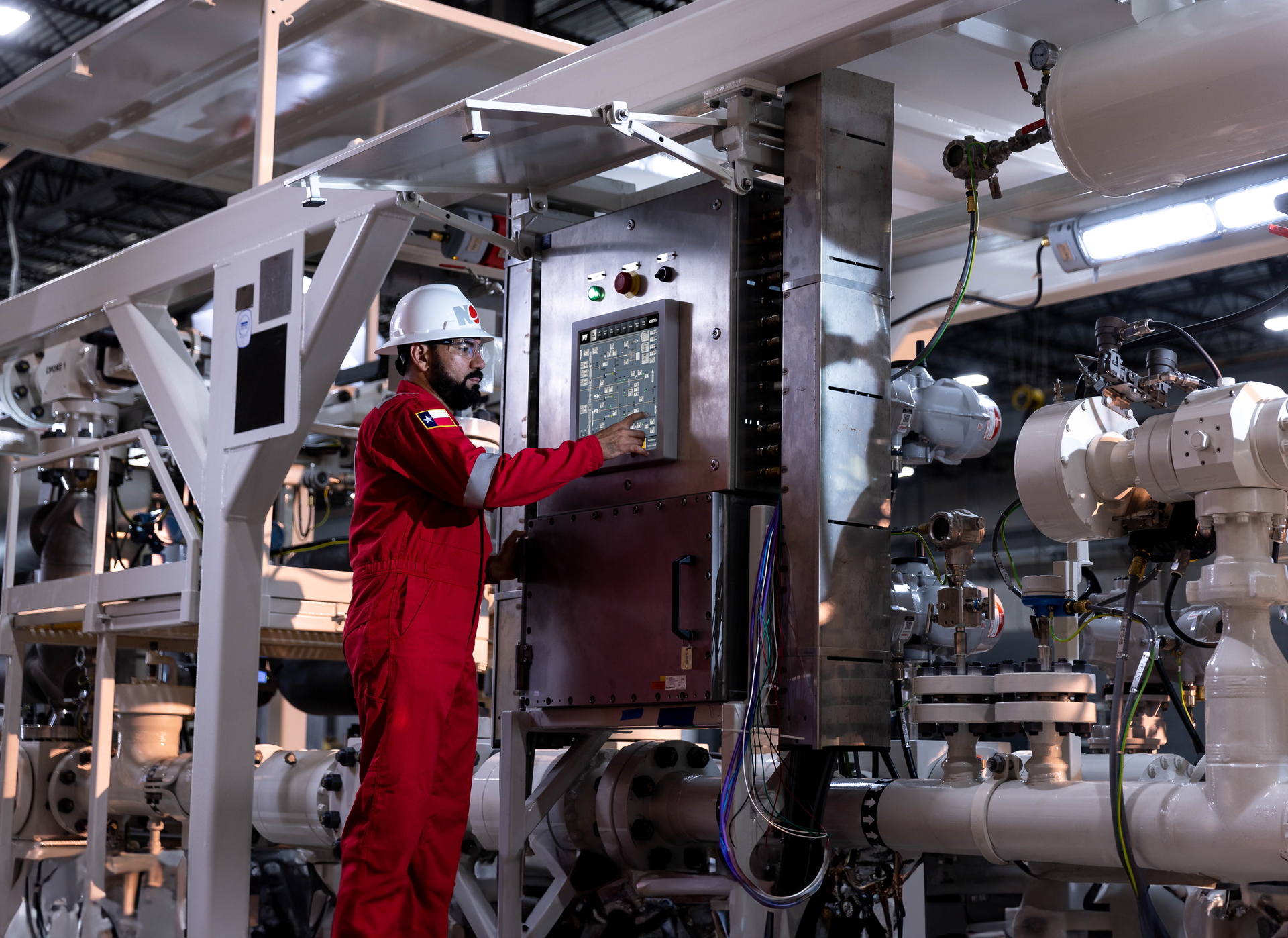 Technician wearing PPE monitoring the Managed Pressure Drilling control systems