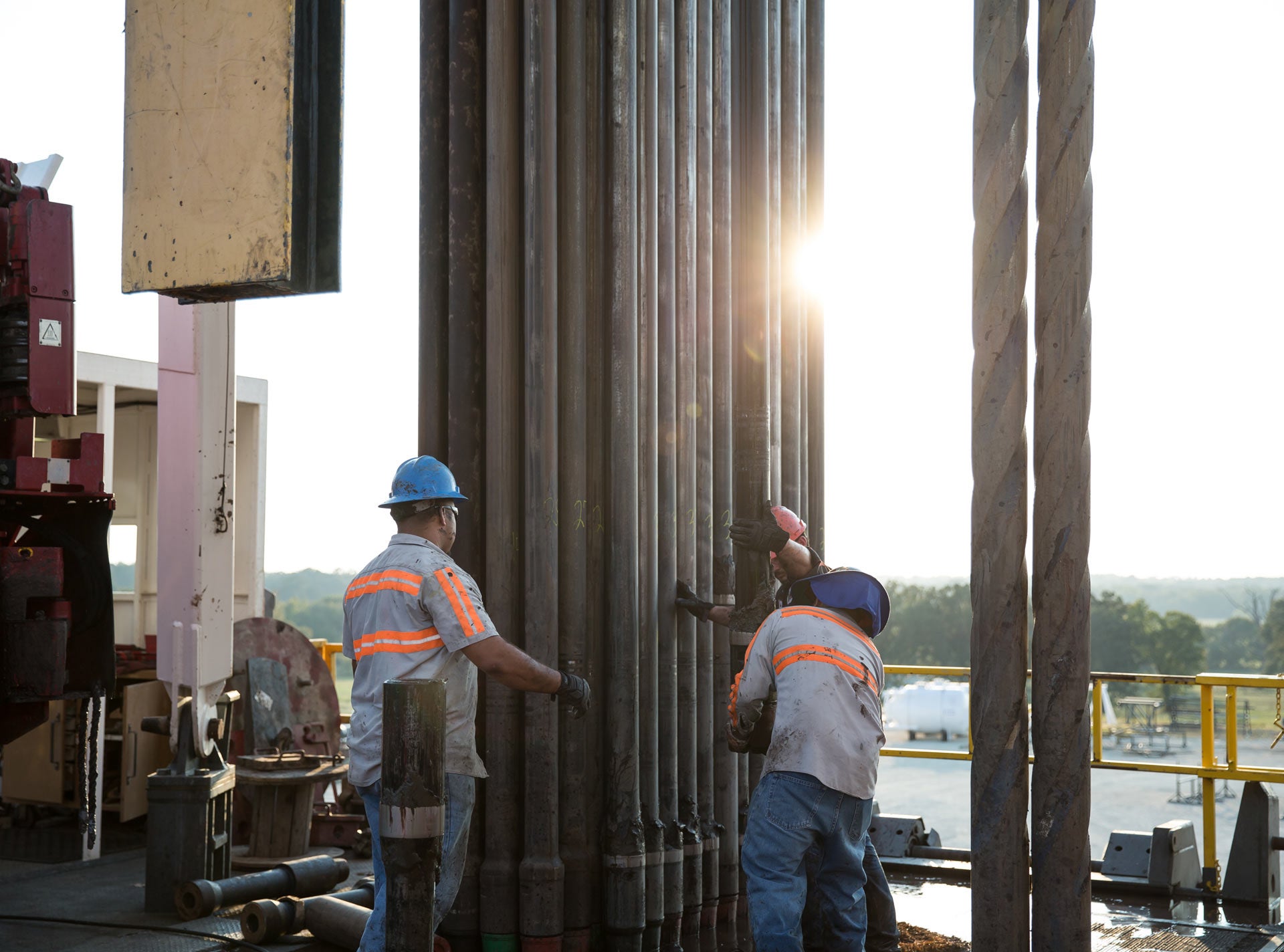 Workers outside touching pipe