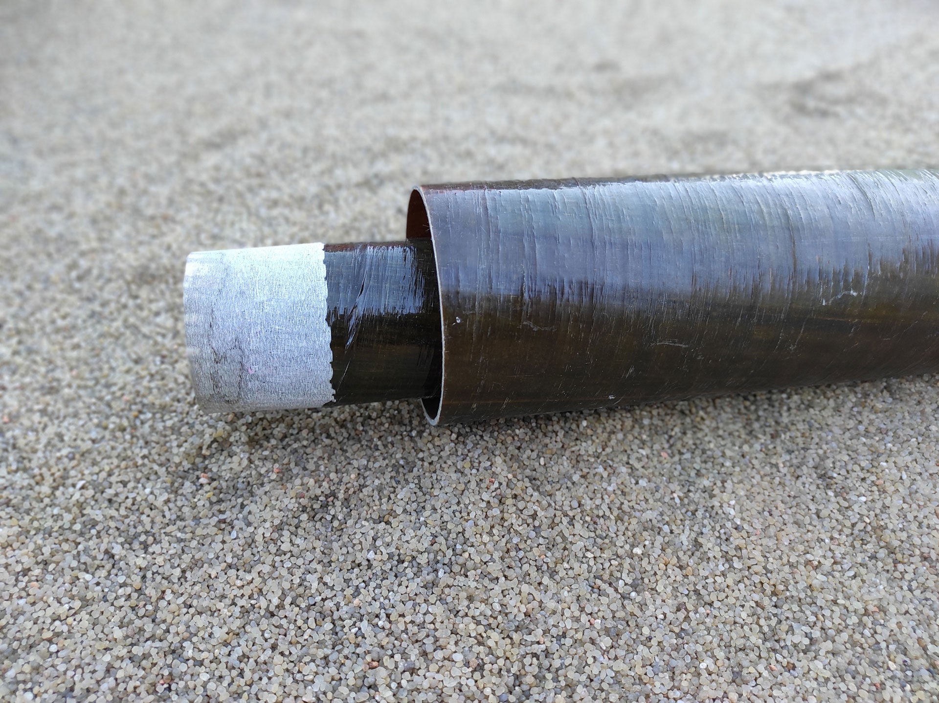 Side view of a Dualoy 3000L Fiberglass Pipe on the ground