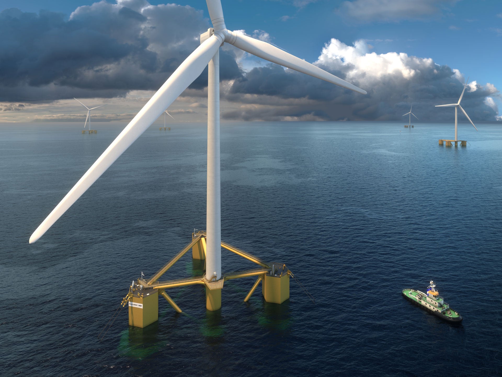 Close up of a wind turbine with more turbines in the background on a cloudy day