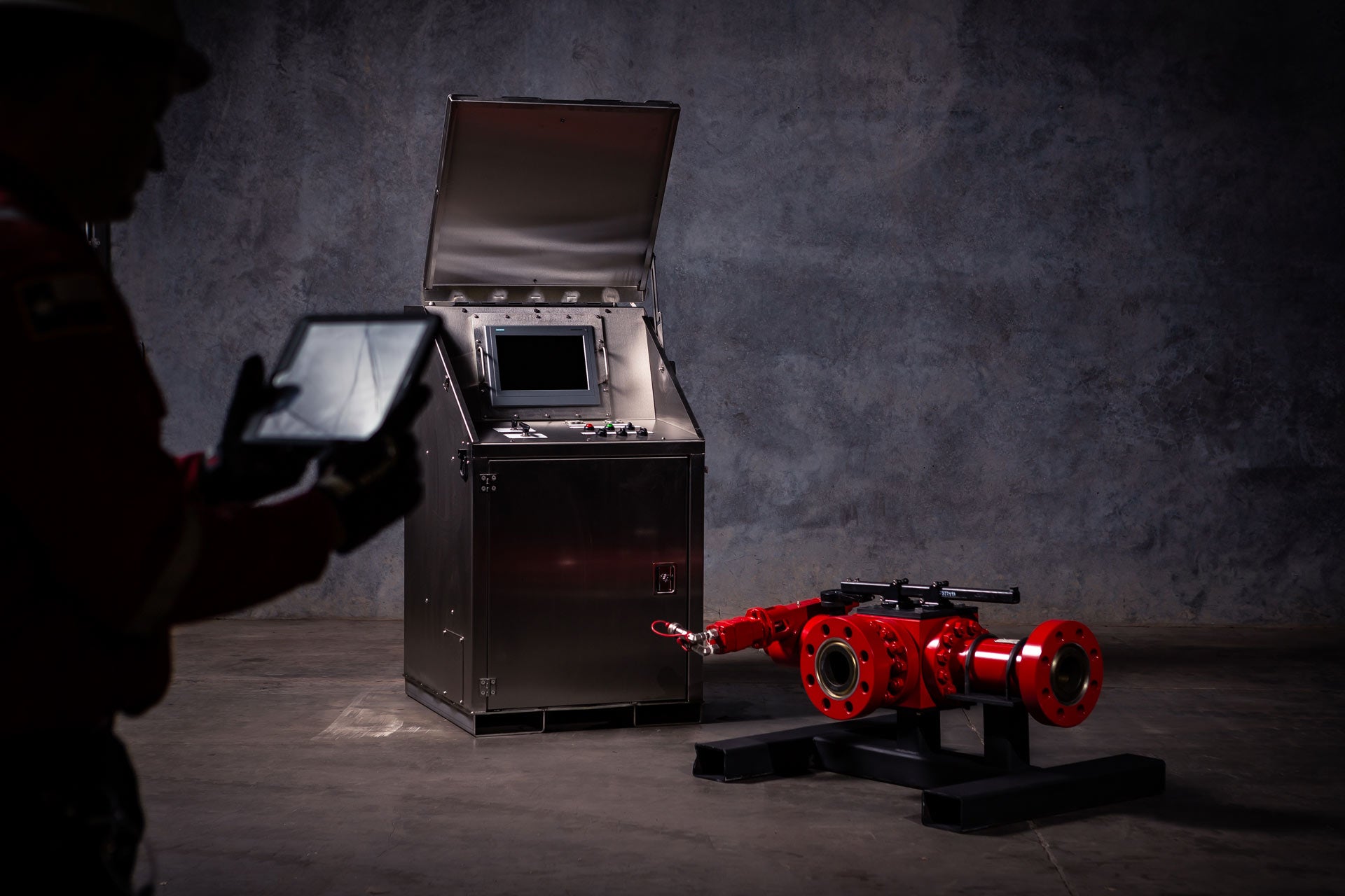 A silhouetted employee uses the remote software connected to the MPowerD Choke Manifold 1500M/1500S