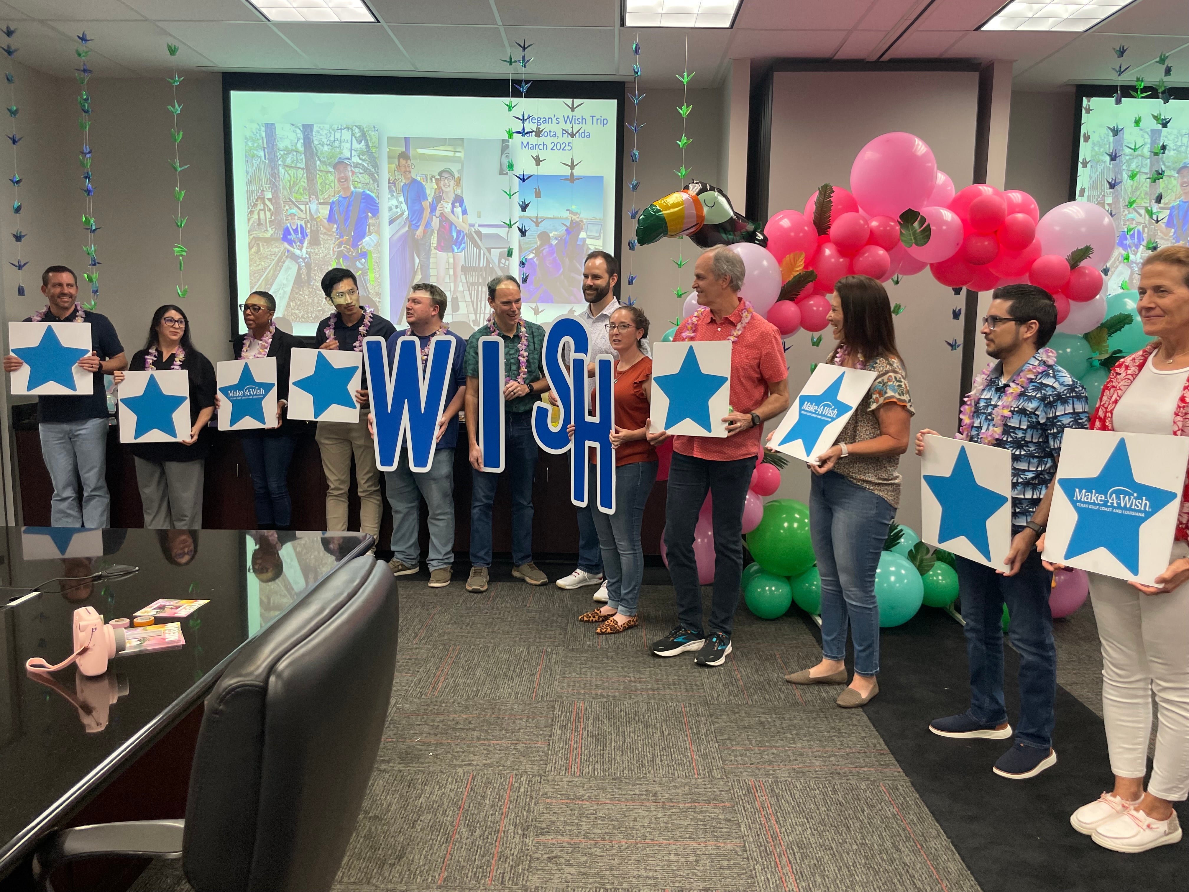 Group formed to spell out WISH and holding star signs for a Make-A-Wish event
