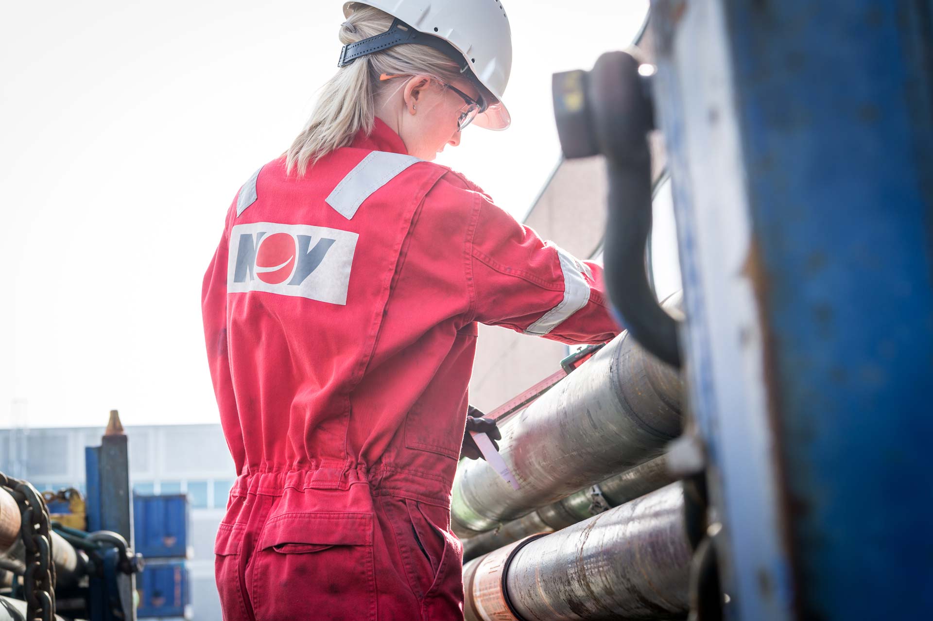 An NOV employee measures a portion of pipe