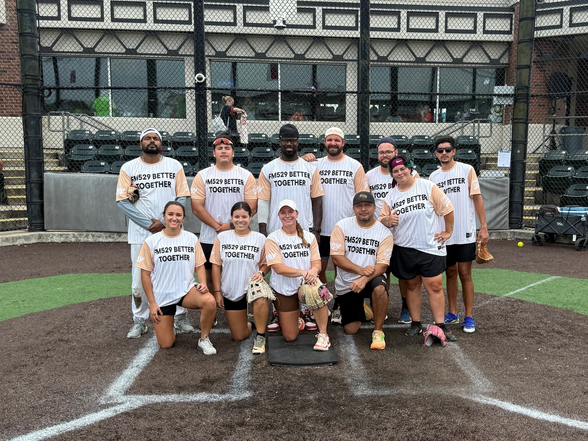 FM529 Better Together team posed at home base at Derricks and Diamonds softball charity tournament