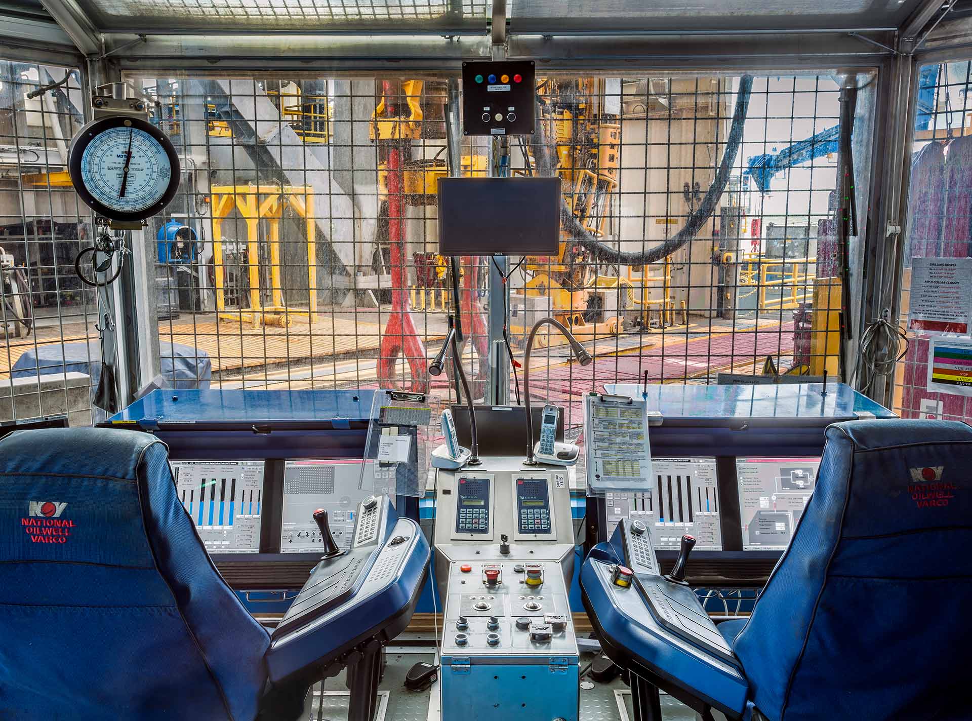 Two NOV Cyberbase drillers chairs and drilling monitor screens in drilling cabin on offshore platform