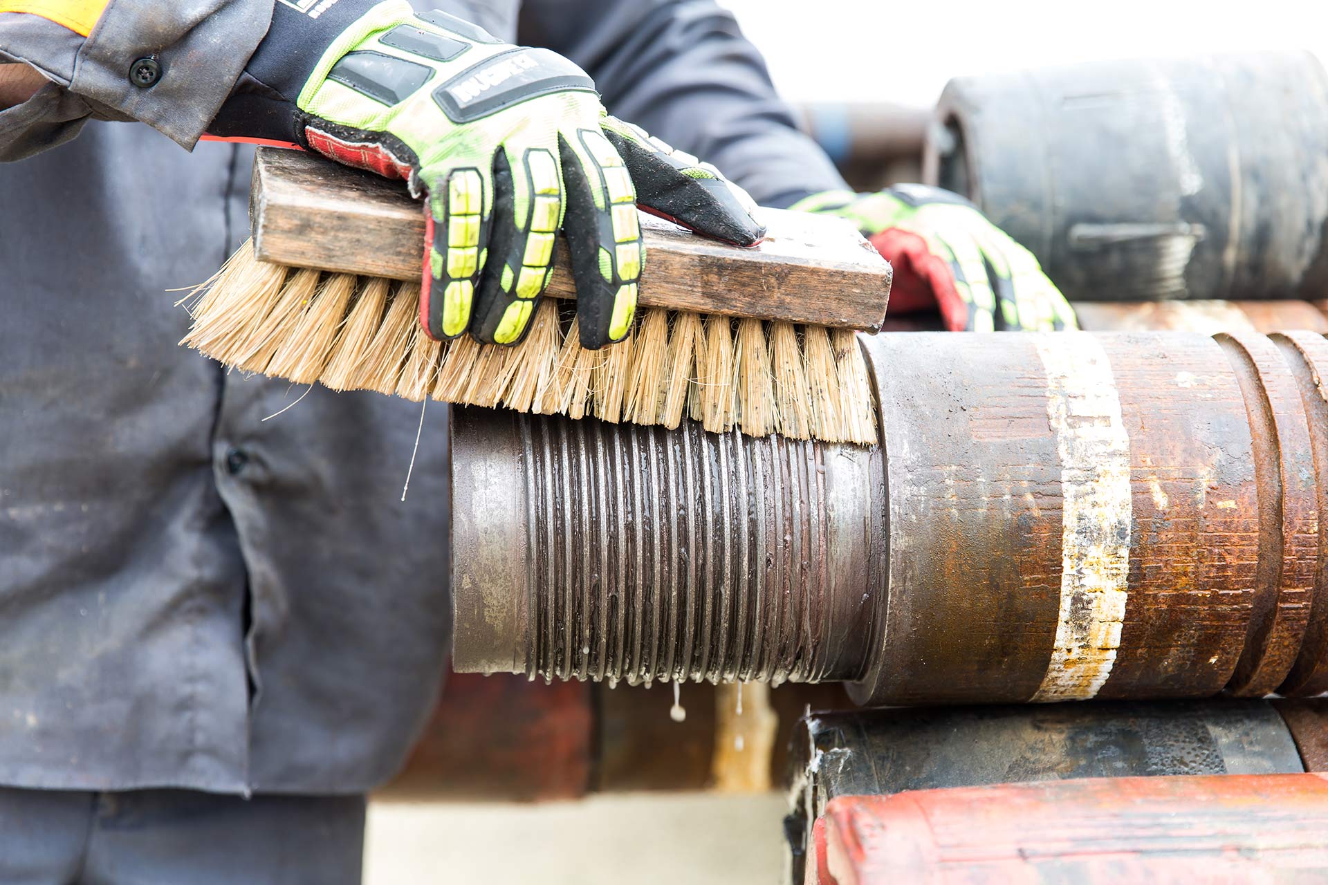 Technician cleaning pipe thread