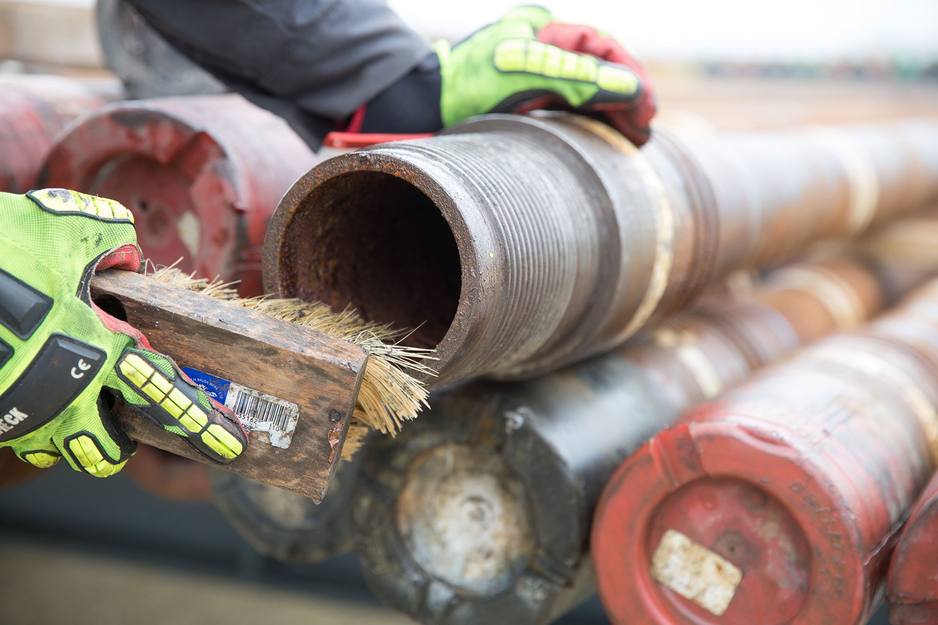 Technician cleaning pipe with brush