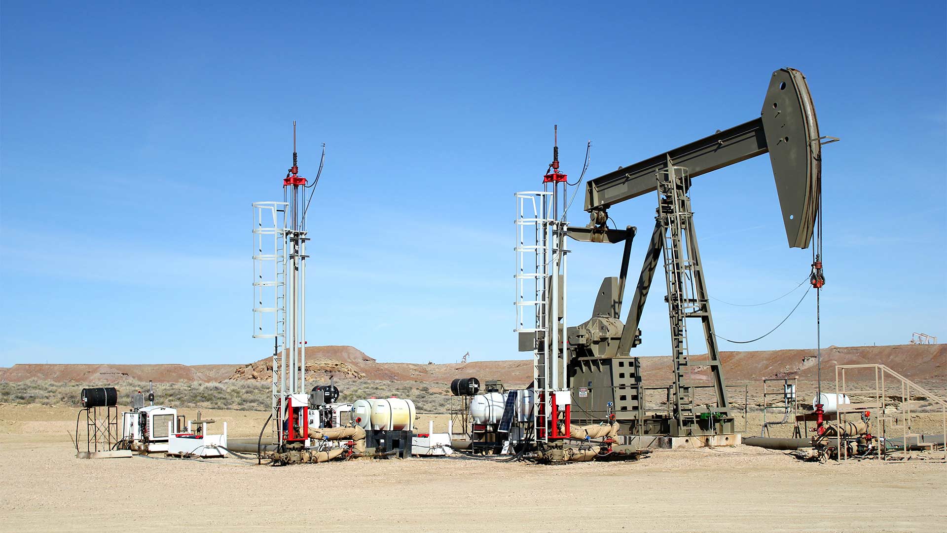 A pair of Morlift Hydraulic Rod Pumping Systems installed near a pump rig