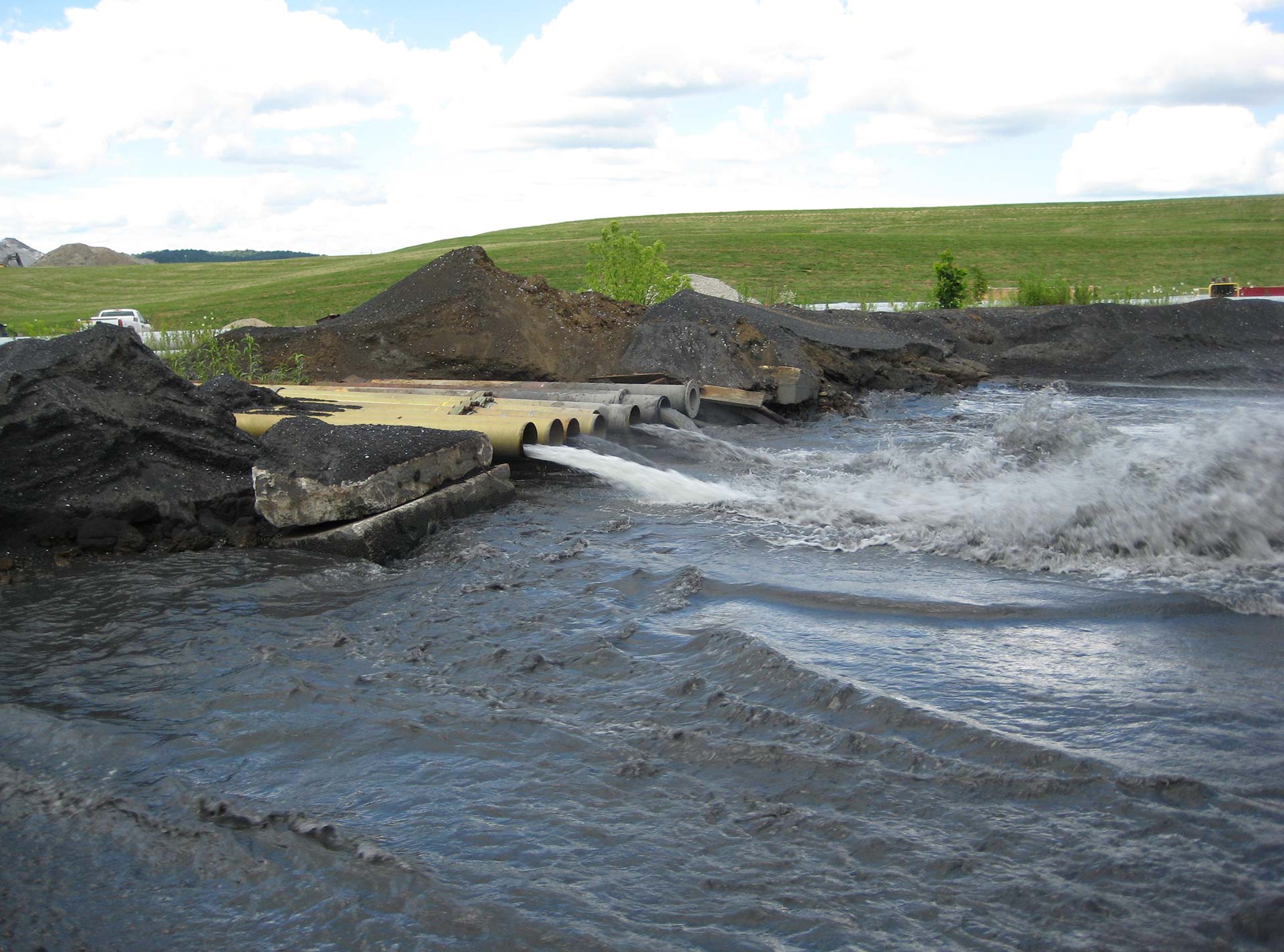 A row of Ceram Core Fiberglass Pipe drain water into a reservoir