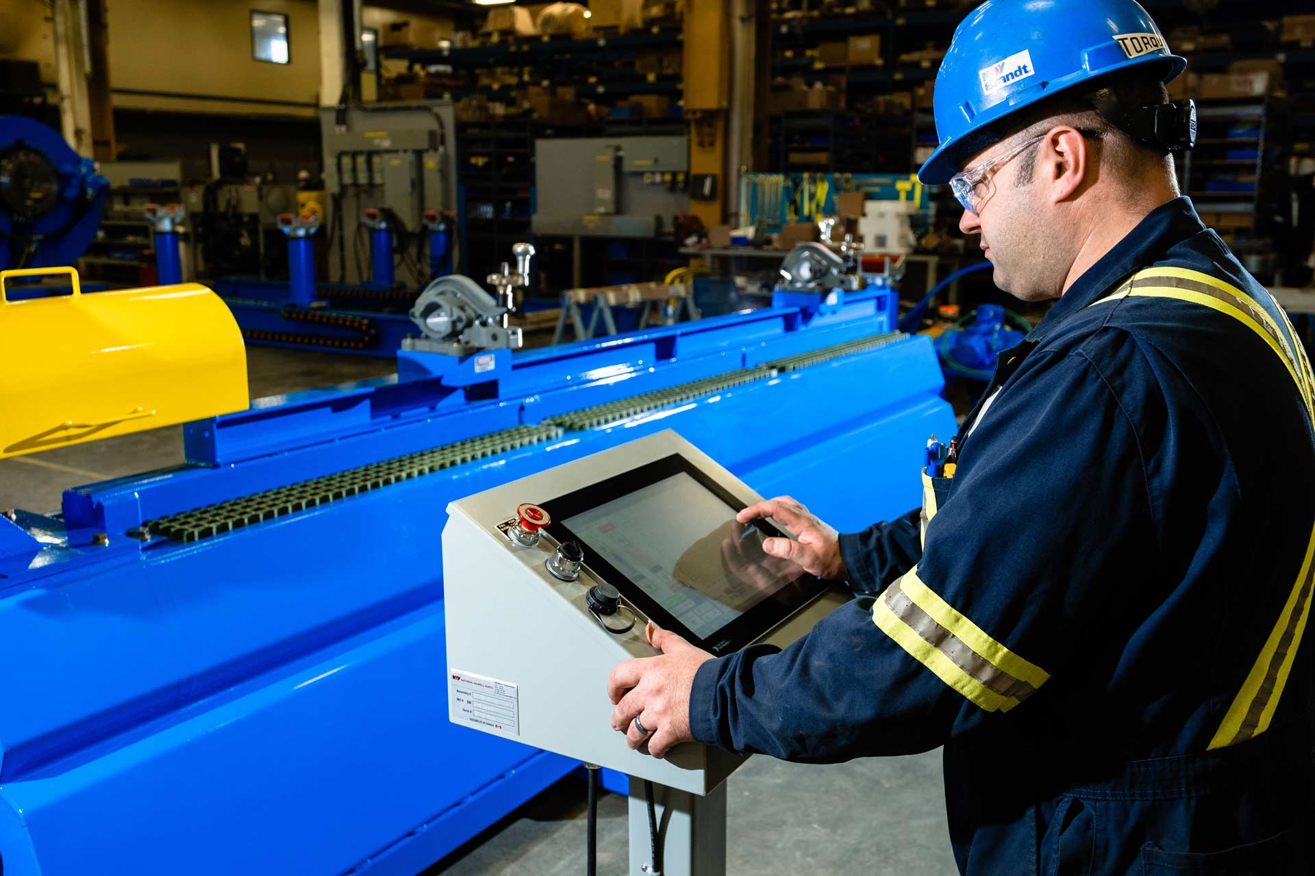 A worker touches the screen of the Coiled Tubing Motor Test Stand